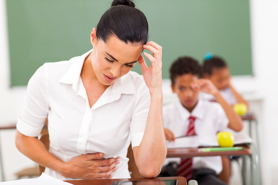 elementary school female teacher feeling sick in classroom due to poor indoor air quality
